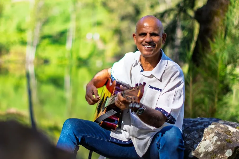 Frédéric Joron, guitare à la main, au bord de l'eau